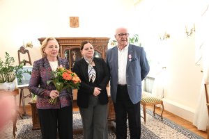 Starsi państwo i kobieta w granatowej marynarce