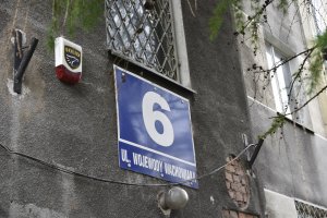Fragment budynku z tabliczką adresową przy ulicy Wachowiaka 6