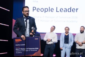 Mężczyzna w garniturze ze statuetką