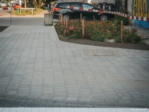 na pierwszym planie widoczny chodnik z kostki, w tle zieleń