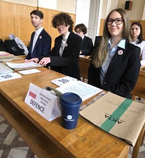 Młodzi ludzie w za stolikiem, na pierwszym planie akta