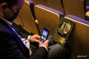 Jeden z laureatów fotografuje telefonem komórkowym nagrodę "Czas Gdyni" // fot. Karol Stańczak