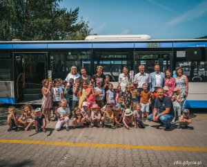 Wizyta przedszkolaków w zajezdni PKA, zdjęcie grupowe, w tle autobus