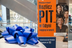 Tablica z napisem  &bdquo;Rozlicz PIT w Gdyni&rdquo; i wygraj w loterii