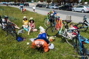 na zdjęciu rowerzyści leżący lub siedzący na trawie