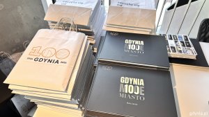 Książka Marii Jarosz &bdquo;Gdynia moja miasto&rdquo; i papierowe torby z napisem: 100 Gdynia