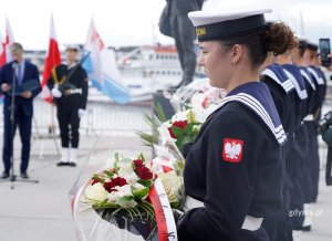 na zdjęciu żołnierka trzyma kwiaty