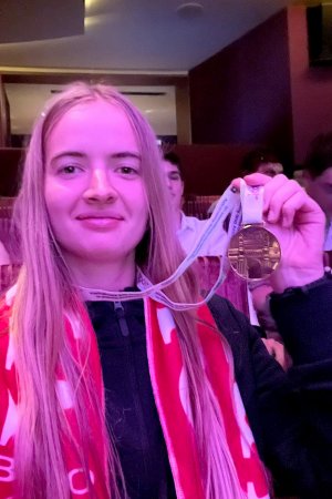 Kobieta trzymająca z dumą brązowy medal