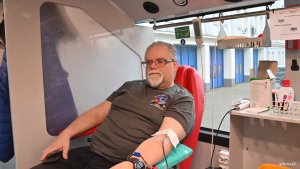 Mężczyzna w okularach na fotelu oddaje krew