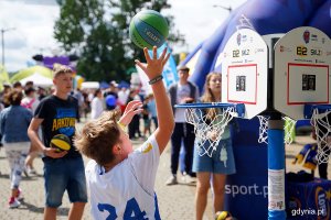 Młodzi ludzie z piłkami do kosza w rękach grają na torze sportowym w miasteczku stoczniowo-marynarskim podczas Dnia Marynarki Wojennej i Dnia Stoczniowca 