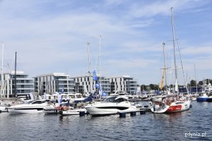 Różnego rodzaju jachty są zacumowane przy kei w Marina Yacht Parku w Gdyni. Na kei ludzie oglądający łodzie // fot. Magdalena Czernek