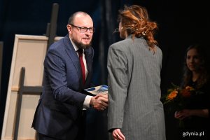 Mariusz Bzdęga - dyrektor zarządzający ds. kultury i aktywności mieszkańców wręcza Nagrodę Prezydent Miasta Gdyni z okazji Międzynarodowego Dnia Teatru aktorce Julii Pawlak z Teatru Czwarte Miasto 