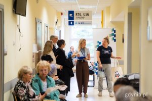 Pracownice udzielają informacji uczestnikom akcji profilaktycznej w korytarzu plac&oacute;wki medycznej