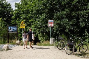 Dwoje ludzi podchodzi do wejścia na plażę.
