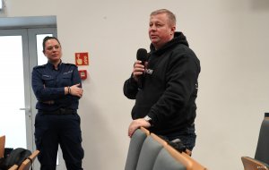 Mężczyzna z mikrofonem i kobieta w mundurze policyjnym