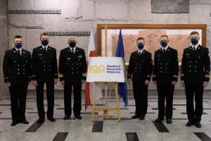 Rektor Akademii Marynarki Wojennej w Gdyni wraz z podchorazymi prezentują logo stulecia AMW // fot. materiały prasowe AMW
