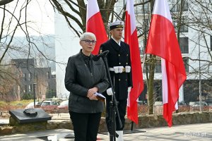 Joanna Zielińska, przewodnicząca Rady Miasta Gdyni, przemawiająca podczas obchodów 83. rocznicy zbrodni katyńskiej, które odbyły się na Cmentarzu Wojennym w  Redłowie. Za nią marynarz z posterunku honorowego stojący na tle biało-czerwonych flag // fot. Magdalena Czernek