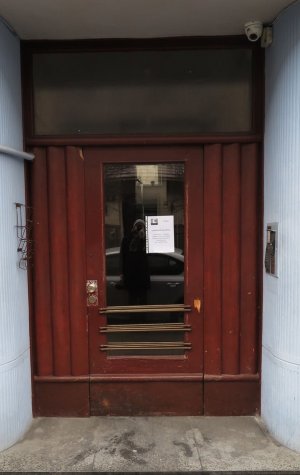 Bordowe drzwi wejściowe do budynku przy ul. Bema 4.