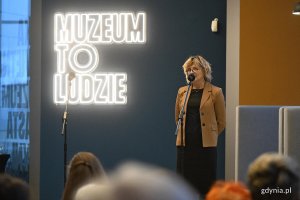 Na zdjęciu: dyrektorka Muzeum Miasta Gdyni Karin Moder na tle neonu: muzeum to ludzie