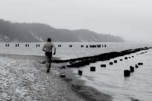 Tytuł zdjęcia: Mężczyzna rozgrzewa się przed wejściem do wody, autorka: Joanna Wawiernia, lokalizacja: Gdynia, Morze Bałtyckie 