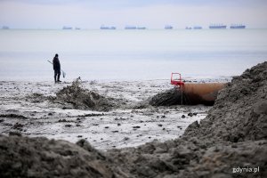 Woda płynie z rury na plaży.