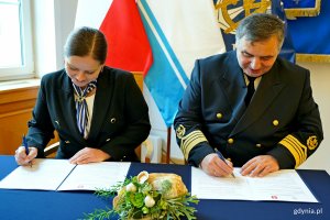 Prezydent Aleksandra Kosiorek oraz prof. dr hab. inż. kpt. ż. w. Adam Weintrit, rektor Uniwersytetu Morskiego w Gdyni podpisujący porozumienie o współpracy między miastem a uczelnią