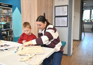 Kobieta z chłopcem malują torby