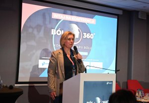 Kobieta w brązowej marynarce z mikrofonem