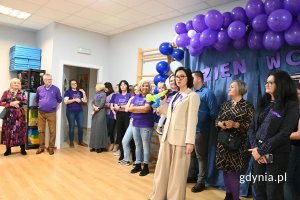 Grupa osób stojących w przedszkolnej sali