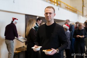 Radny miasta Norbert Anisowicz roznoszący świąteczne potrawy gościom wigilii dla samotnych i potrzebujących