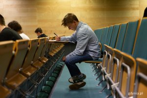 Chłopka w niebieskiej koszuli rozwiązuje test 