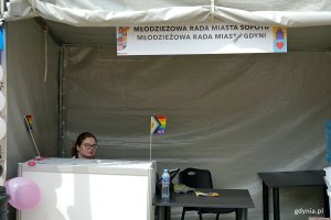 Uśmiechnięta dziewczyna na stoisku Młodzieżowej Rady Miasta Gdyni na Przystanku Równość 