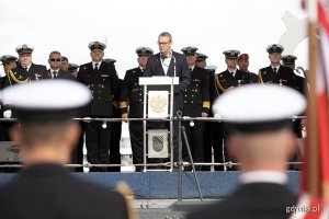 Na pierwszym dwóch stojących tyłem marynarzy. W środku: Marcin Wołek - wiceprzewodniczący Rady Miasta Gdyni wygłaszający przemówienie okolicznościowe podczas apelu z okazji święta 43. Bazy Lotnictwa Morskiego i Dywizjonu Okrętów Bojowych. Za nim w rzędzie stoją przedstawiciele Marynarki Wojennej