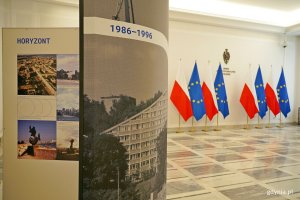 Ekspozytor prezentujący historię Gdyni w latach 1986-1996, a w tle polskie i unijne flagi oraz napis Senat RP