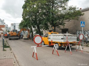 widoczne pojazdy wykkonujące prace drogowe oraz oznakowanie, trwa remont nawierzchni
