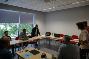 Finaliści konkursu "Morze mnie kręci" na warsztatach filmowych w Gdyńskiej Szkole Filmowej. Patrzą na ustawiony na stole laptop z prezentacją // fot. ARG