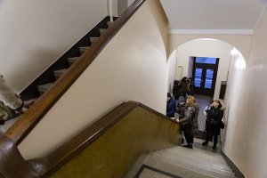 Grupa osób na klatce schodowej robi zdjęcia.