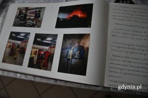 Otwarta księga z wklejonymi w nią zdjęciami i wpisanym tekstem