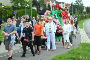 Mieszkańcy i szczudlarze biorący udział w paradzie.
