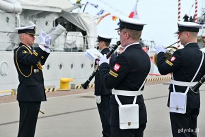 Marynarze grający na instrumentach i dyrygent Orkiestry Reprezentacyjnej Marynarki Wojennej przed okrętem ORP „Błyskawica” podczas uroczystości z okazji Dnia Flagi RP// fot. Magdalena Czernek