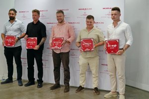 Restauratorzy, kt&oacute;rzy zdobyli rekomendacje przewodnika Michelin 2026 z plakietami. Wśr&oacute;d nich (w środku) Piotr Ciomek z Oberży 86 