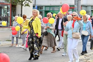 Uczestnicy przemarszu w ramach V Pomorskiego Dnia Seniora. W kolorowych strojach i z balonami w rękach.