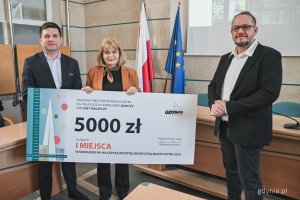 Wręczenie nagród w konkursie na najlepszą witrynę świąteczną w Gdyni - nagrodę odbiera przedstawicielka kwiaciarni Narcyz (fot. Kamil Złoch)
