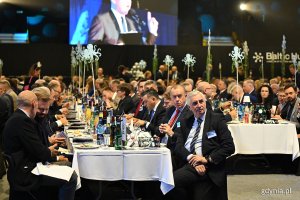 Goście siedzą przy zastawionych stołach