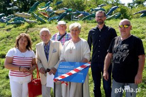 na zdjęciu osoby odsłaniające tablicę