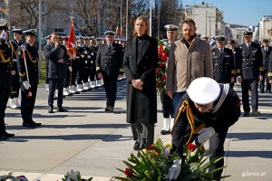 Delegacja gdyńskich samorządowców składająca kwiaty pod pomnikiem Polski Morskiej. Od lewej: Anna Chojnowska - naczelniczka Biura Prezydenta oraz radny Łukasz Strzałkowski. Na pierwszym planie marynarz składający kwiaty