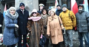 Grupa os&oacute;b pod pomnikiem