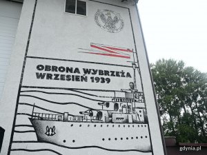 Prawa strona muralu „Chwała polskim marynarzom”. Na dole: fragment okrętu ORP „Wicher”, powyżej niego napis „Obrona Wybrzeża, wrzesień 1939”. W prawym górnym rogu symbol Ministerstwa Obrony Narodowej