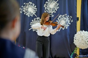 Nauczycielka grająca na skrzypcach podczas uroczystości z okazji 90-lecia SP nr 11