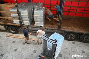 Mężczyźni ładują do ciężarówki paczki z pomocą dla Chersonia